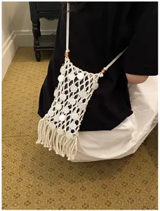 Bohemian hand-woven macrame phone bag with white shell sequins and long fringe detail.