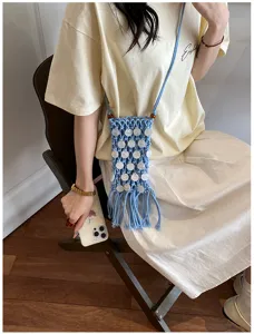 Minimalist blue hand-woven crossbody phone bag with fringe detail shown in casual lifestyle outfit