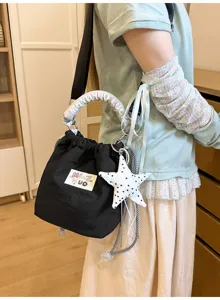 Vista dettagliata di una borsa a secchiello nera stile giapponese con ciondolo a stella.