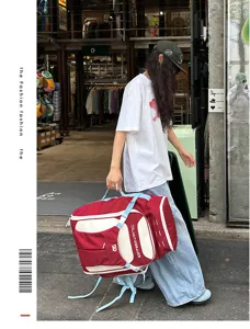 Große rot-weiße Reisetasche im Color-Block-Design, im Street-Style getragen.