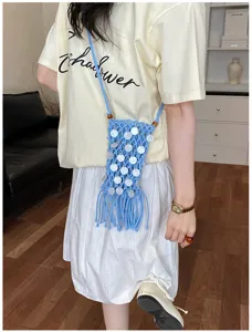 Blue woven macrame phone bag with white sequins and tassel fringe shown on model
