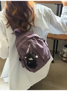 Detailansicht des vintage gewaschenen Canvas-Minirucksacks mit süßem Plüsch-Schaf-Anhänger.