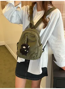 Vintage gewaschener Canvas Mini Rucksack Detail mit süßem Puppenanhänger für Freizeit.