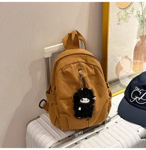 Detailansicht des vintage Canvas Mini-Rucksacks mit einem flauschigen Schaf-Anhänger.