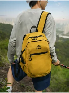 Vue arrière d'un sac à dos de randonnée jaune porté par un modèle en pleine nature