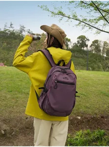 Mannequin asiatique avec sac à dos violet pour voyage dans un champ de verdure