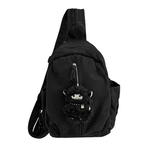 Schwarzer Canvas Brusttasche Detail mit einem niedlichen flauschigen schwarzen Schaf Anhänger.