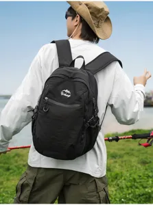 Sac à dos de randonnée noir porté par un mannequin dans un champ d'herbe