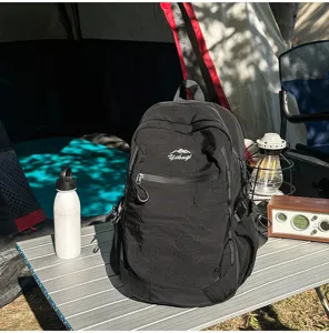 Vue détaillée d'un sac à dos de randonnée noir sur une table de camping avec accessoires