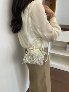 Elegant pearl beaded handbag for women, stylish hollow crossbody shoulder bag with drawstring.