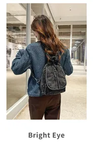 Asiatisches Modemodell mit stylischem Vintage-Rucksack aus gewaschenem Denim im modernen Flur