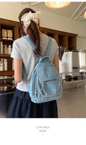 Detailed lifestyle shot of a vintage washed denim multi-pocket backpack for women