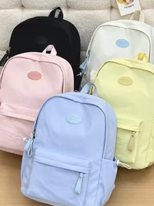 Nahaufnahme von bonbonfarbenen Schülerrucksäcken in Pink, Blau, Gelb, Schwarz und Weiß
