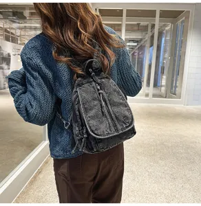 Rückansicht eines stylischen, vintage gewaschenen Denim-Rucksacks mit blauem Strickpullover