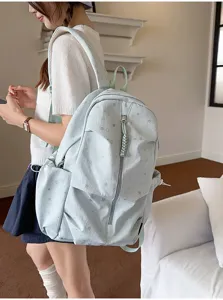 Inquadratura di dettaglio di uno zaino azzurro con stelle indossato da una modella