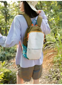 Vue arrière d'un mannequin portant un sac à dos de randonnée en nylon coloré en forêt