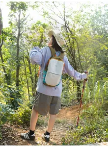 Modèle féminin en randonnée avec un petit sac à dos en nylon aux couleurs contrastées.
