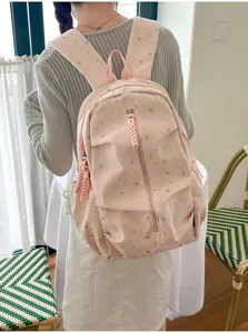 Vista posteriore di uno zaino rosa con stampa di stelle indossato da una modella