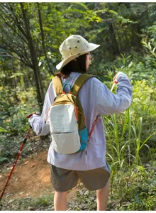 Femme asiatique en randonnée portant un sac à dos de sport extérieur en nylon bicolore