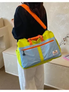 Large color-block travel crossbody bag shown being worn by a person from the back