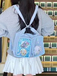 Close-up of a blue star-patterned ita bag with transparent display pockets worn by a model