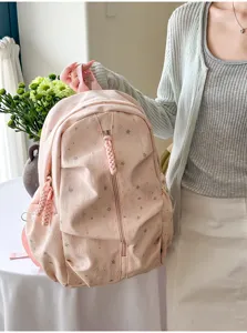 Vista lifestyle di un grazioso zaino rosa per studenti con stampe di stelle e trecce