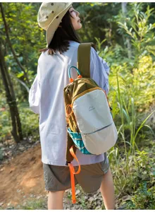 Photo de mode en plein air d'une femme portant un sac à dos de randonnée en nylon coloré.