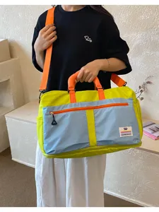 Detail view of colorful outdoor travel bag with adjustable orange shoulder strap