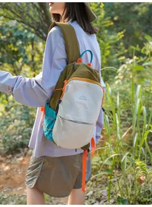 Sac à dos outdoor en nylon color-block stylé porté par un mannequin en forêt dense