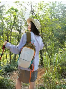 Femme portant un sac à dos de randonnée en nylon bicolore en forêt
