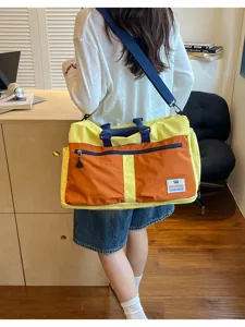 Large capacity color-block travel crossbody bag shown being worn by a model in a room.