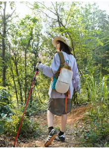 Vue arrière d'une randonneuse portant un petit sac à dos de randonnée coloré en nylon