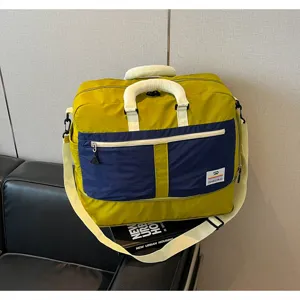 Large color-block travel bag with dual handles and adjustable shoulder strap detail