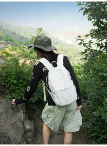 Randonneuse avec un sac à dos extérieur en nylon blanc léger en milieu montagnard