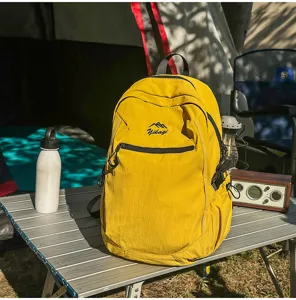 Sac à dos de randonnée jaune durable posé sur une table de camping en aluminium