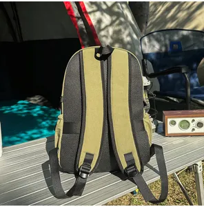 Vue détaillée de l'arrière du sac à dos d'extérieur vert olive sur table de camping