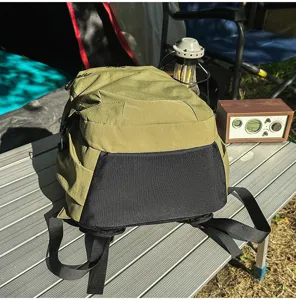Sac à dos de randonnée vert en plein air exposé sur une table de camping réaliste