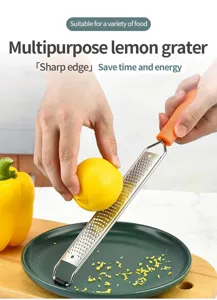Stainless steel lemon grater detail view showing sharp blade and orange handle for cheese.