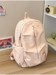 Vista dettagliata dello zaino scolastico rosa con motivo a stelle argentate sulla scrivania