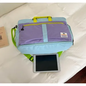 Spacious outdoor travel bag with vibrant color-blocking design shown next to a tablet