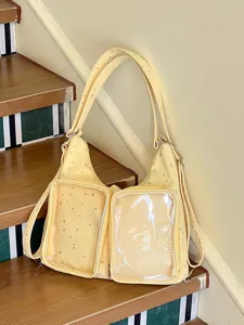 Yellow star-patterned ita bag with transparent display pockets shown on wooden stairs