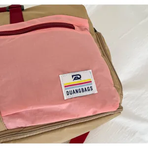 Close-up of a color-block outdoor travel bag showing ripstop fabric and brand label