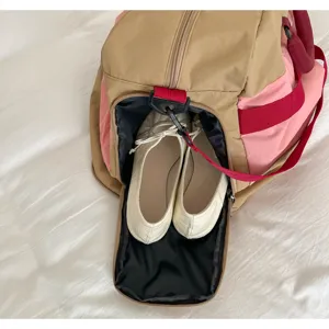 Detail of the separate shoe compartment in a stylish color-blocked outdoor travel duffel bag