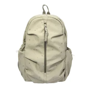 Dettaglio di uno zaino beige con motivi a stelle argentate e cerniera frontale verticale.