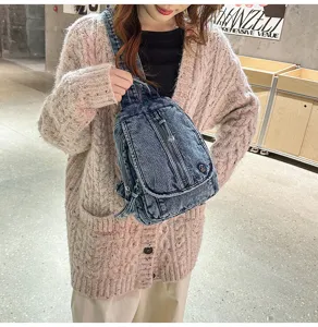 Nahaufnahme einer gewaschenen Denim-Umhängetasche im Retro-Stil als trendige Brusttasche