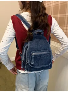 Vintage blue washed denim mini backpack for women in a casual lifestyle setting