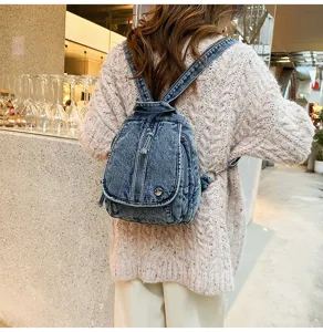 Rückansicht eines vintage gewaschenen Denim-Rucksacks getragen mit cremefarbenem Strickpullover