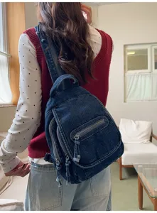 Detailed back view of a vintage blue washed denim chest bag worn by a model in a room