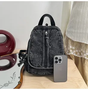 Schwarzer Vintage-Rucksack aus gewaschenem Denim mit Smartphone als Größenreferenz