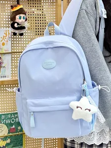 Nahaufnahme eines hellblauen Schulrucksacks mit einem süßen Plüschstern-Anhänger